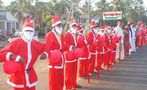 People dressed as Santa Claus participate in the human chain